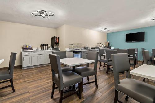 a dining room with tables and chairs and a kitchen at Sleep Inn Kelso Longview in Kelso