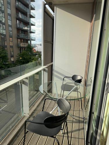 two chairs and a glass table on a balcony at Lovely cosy flat in Manchester