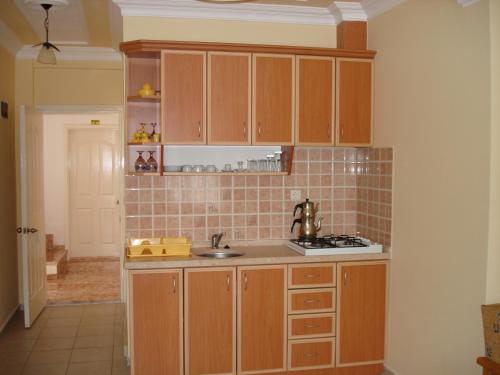 a kitchen with wooden cabinets and a sink at Ada Apart Hotel in Dalyan
