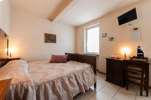 a bedroom with a bed and a desk and a television at Agriturismo Ceolara in Sommacampagna