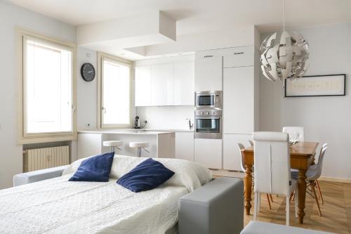 una camera da letto con un letto e una cucina con un tavolo di Riverside Apartment a Treviso
