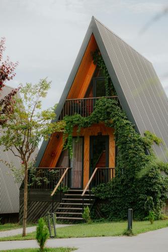 a house with a gambrel roof with stairs and a porch at Reserve Resort Lagodekhi in Lagodekhi