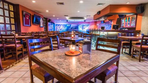 a restaurant with tables and chairs and a bar at Hotel Soleil La Antigua in Antigua Guatemala
