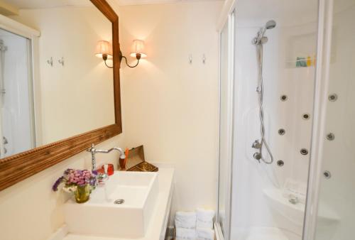 a bathroom with a sink and a mirror and a shower at Residencial Terra de Mar Calpe, Grupo Terra de Mar, alojamientos con encanto in Calpe