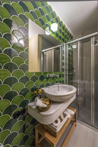 a bathroom with a sink and a green wall at İda Blue Adatepe in Kucukkuyu