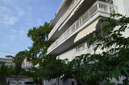 a white building with a balcony on the side of it at Galanis Studios and Apartments in Platamonas