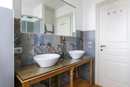 a bathroom with two sinks and a mirror at Riverside Apartment in Treviso