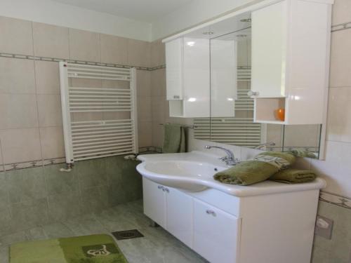 a white bathroom with a sink and a mirror at Holiday House Pine Tree - Three Bedroom Holiday Home with Pool in Nerežišća