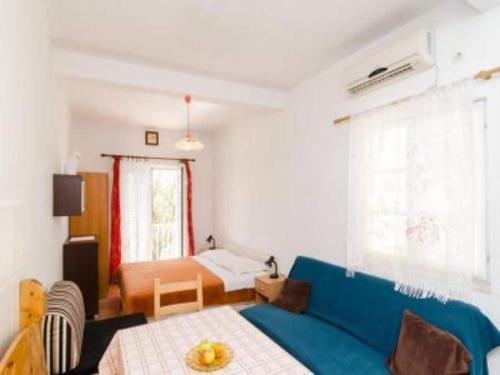 a living room with a blue couch and a bed at Apartments Felix Mljet - Studio with Balcony Felix in Babino Polje
