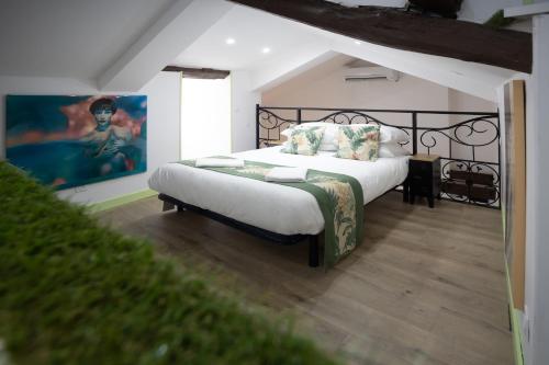 Un dormitorio con una cama y un cuadro en la pared. en Amore-Amore, en Villefranche-de-Rouergue