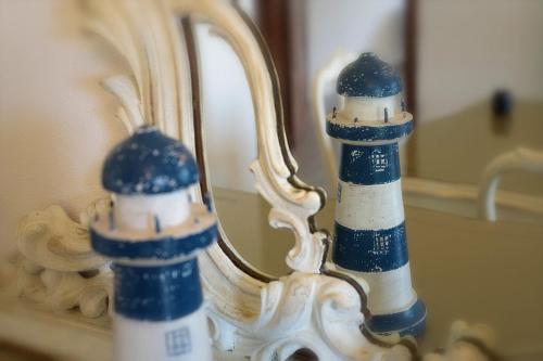a reflection of a lighthouse in a bathroom mirror at B.E.A. Maison in La Spezia