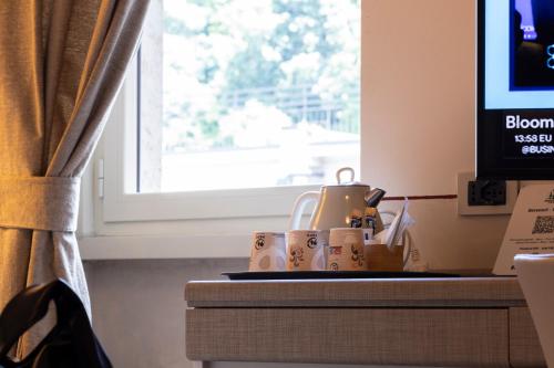 a table with a tea pot and cups on it at Hotel Ambasciatori in Brescia