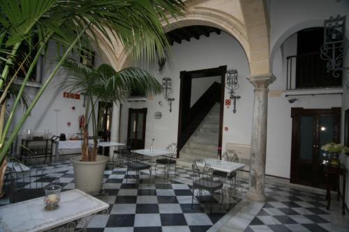 a large room with a table, chairs, and tables at Palacio San Bartolomé in El Puerto de Santa María