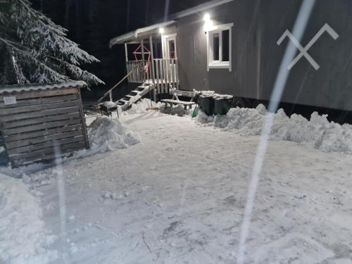 a house is covered in snow at night at Toma pirts MEŽA in Tīnūži