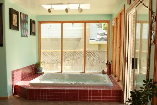 una vasca da bagno in una stanza con finestra di A Garden Stroll Bed & Breakfast a Stratford