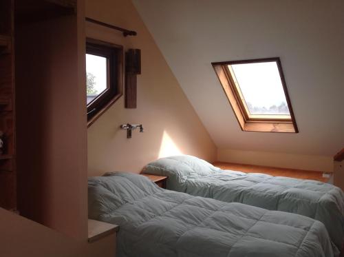 a attic room with two beds and a window at Martina Bungalows in La Ensenada
