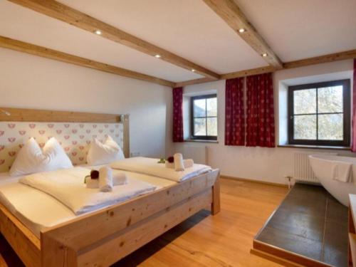 een grote slaapkamer met 2 bedden en een bad bij Appartements Pöllhof in Kitzbühel