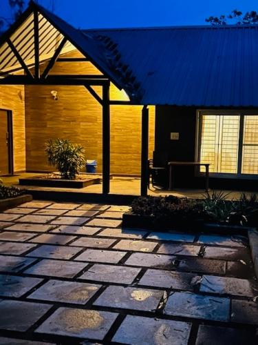 a stone patio with a pavilion in front of a house at 1000 SILVERS -Farm Stay in Mysore