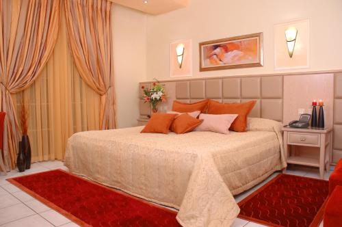a bedroom with a large bed with orange pillows at Hotel Strass in Paralia Katerinis