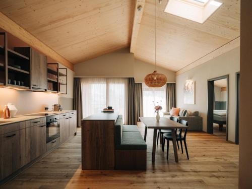 a kitchen with a table and a dining room at KURVE Apartments & Lounge in Adelboden