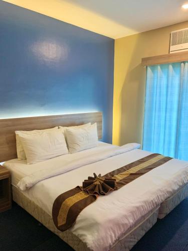 a bedroom with a large bed with a bow on it at Kojo Hotels Premier in Tagum