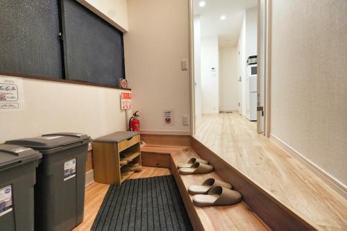 a hallway with a trash can and shoes on the floor at miraisya kyojima in Tokyo