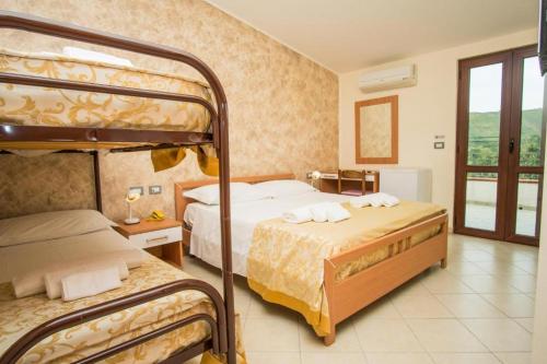 a bedroom with two bunk beds and a balcony at Hotel Palinuro Cilentiamoci rooms in Palinuro
