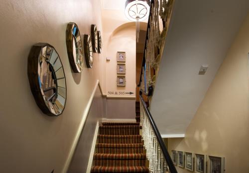 a hallway with stairs and a mirror on the wall at Best Western Buckingham Palace Rd in London