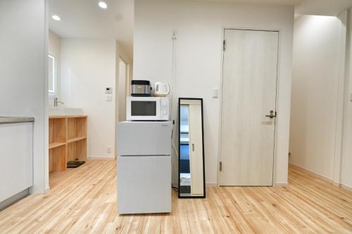 a kitchen with a refrigerator and a microwave at miraisya kyojima in Tokyo