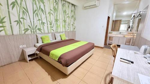 a bedroom with a large bed and a bathroom at Hotel Huswah Airport in Jakarta