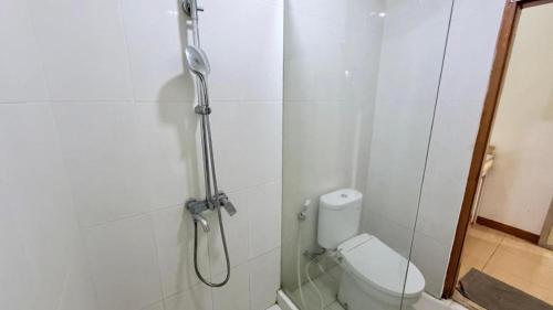 a shower in a bathroom with a toilet at Hotel Huswah Airport in Jakarta