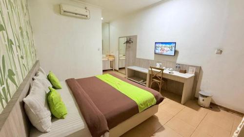 a bedroom with a bed and a bathroom with a sink at Hotel Huswah Airport in Jakarta
