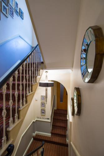 a staircase in a house with a round mirror at Best Western Buckingham Palace Rd in London