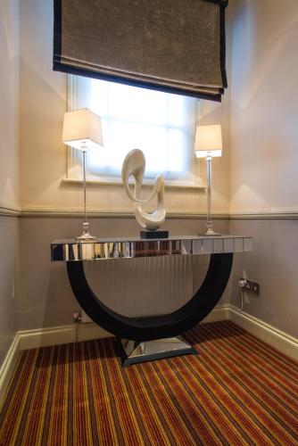 a table with a sculpture on it in a room with two lamps at Best Western Buckingham Palace Rd in London