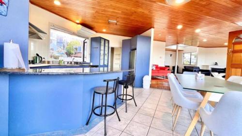 an open kitchen and dining room with a blue bar at Tranquil Haven Retreat in Auckland