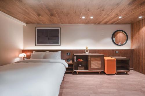 庆州Gyeongju Coolstay hotel的带一张大床和一面镜子的卧室