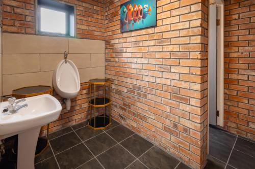 a bathroom with a sink and a brick wall at Mount Rd Ocean View in Gqeberha