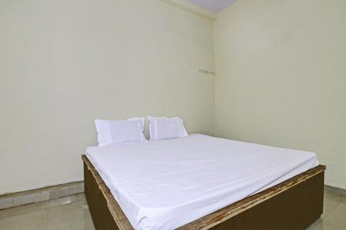a bed in a room with white sheets and pillows at SPOT ON 81062 Moonlight Hotel in Bhilai