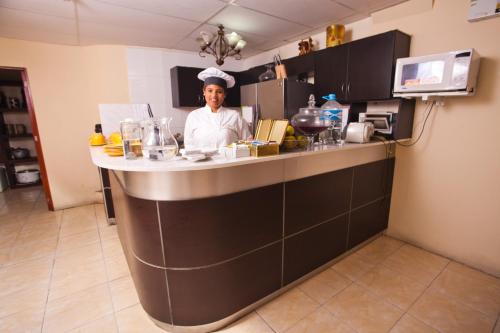 a chef standing behind a counter in a kitchen at Hotel El Farolito in Lima