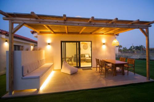 a patio with a wooden table and a wooden pergola at Kalliopi Luxury Apartments in Kalliópi