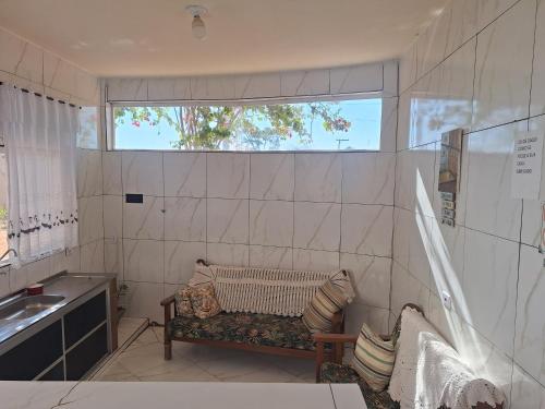 a bathroom with a bench and a sink and a window at Rancho da Nice in Presidente Epitácio