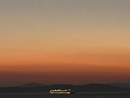 a sunset with a building in the distance at House by the sea in Kea Cyclades in Melissaki