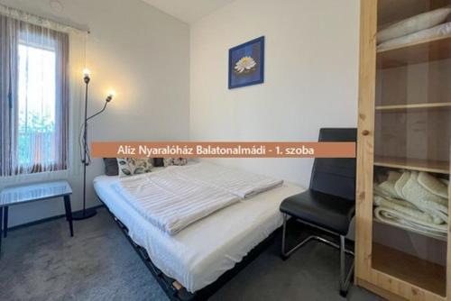 a bedroom with a bed and a chair in it at Alíz nyaralóház in Balatonalmádi