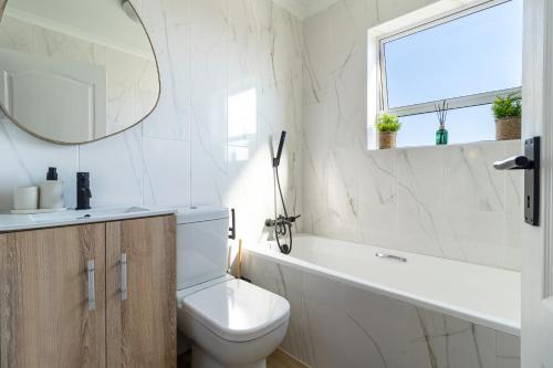 a bathroom with a toilet and a sink and a mirror at 2 Bedroom, Mountain View Penthouse, Century City in Cape Town