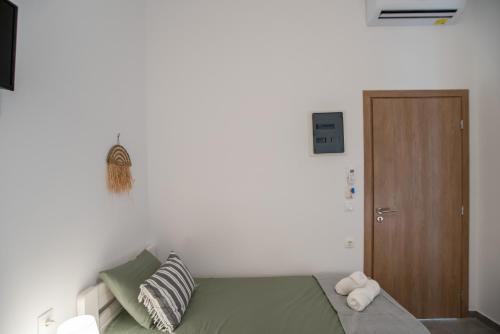a bedroom with a green bed and a wooden door at Olesia Rooms in Naousa in Naousa