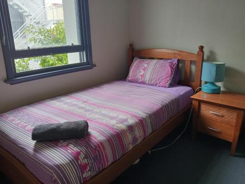 una piccola camera da letto con un letto e una finestra di Australia Hotel Fremantle a Fremantle