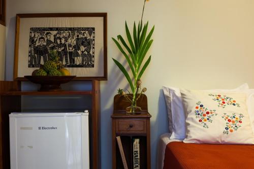 a room with a bed with a pillow and a plant at Pousada Casa da Vitória in Salvador