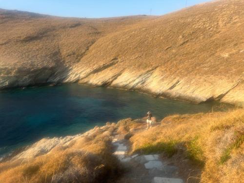 a person standing on a hill next to a river at House by the sea in Kea Cyclades in Melissaki