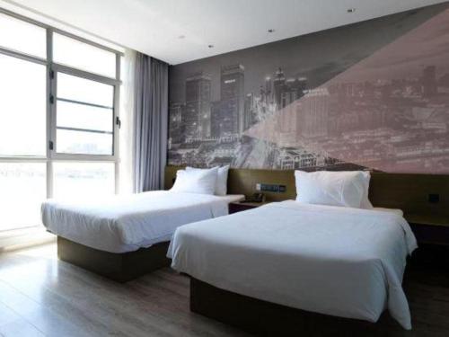 Postel nebo postele na pokoji v ubytování ibis Styles Wuhan Optics Valley Square Hotel