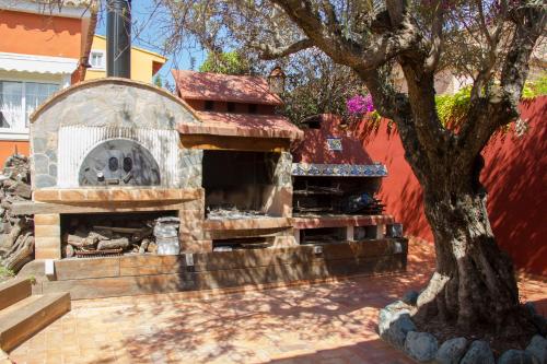 a stone oven in a yard with a tree at Hotel Iris La Eliana in La Eliana
